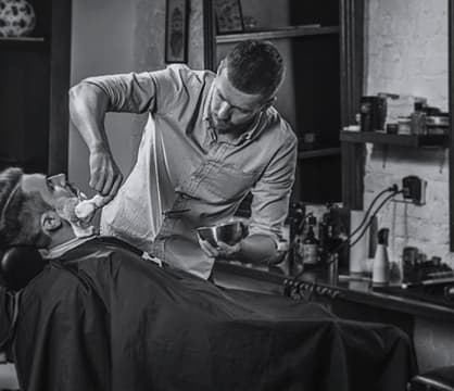 Barber applies foam to the client's face
