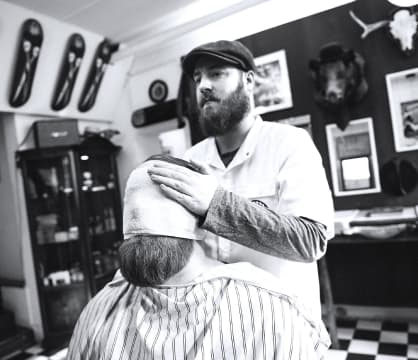 Barber puts a towel on the client's face