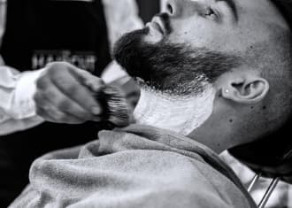 Barber applies foam to the client's face